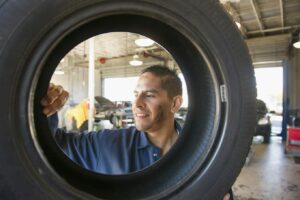 mechanik oglądający oponę samochodu