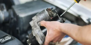 mechanik trzymający rozrusznik samochodowy