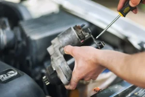 mechanik trzymający rozrusznik samochodowy